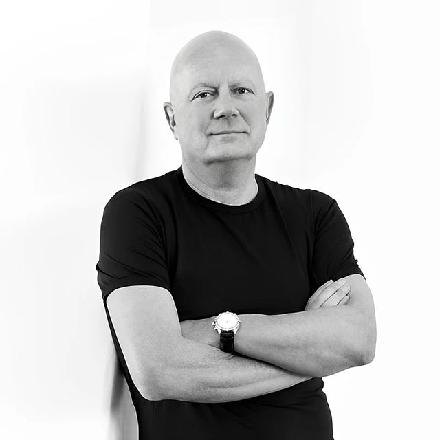 Black and white portrait of a person with arms crossed wearing a black shirt and watch.